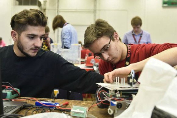 Simon Zohrabyan (left) and teammate Areg Karapetyan take time to modify their robot during their first day of the National Robotics Challenge held at the Veterans Memorial Coliseum on Thursday (Photo: Matthew Hatcher/The Marion Star)