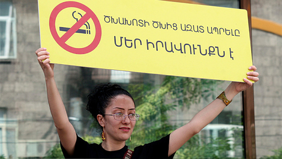 Protester holds sign that translates "Living Free From Tobacco Smoke is our Right" (Photo: Photolur)