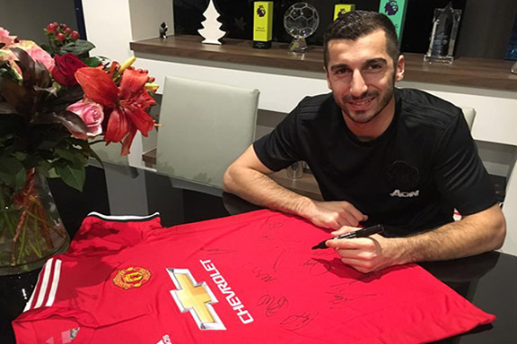 Henrikh Mkhitaryan signs his Manchester United jersey