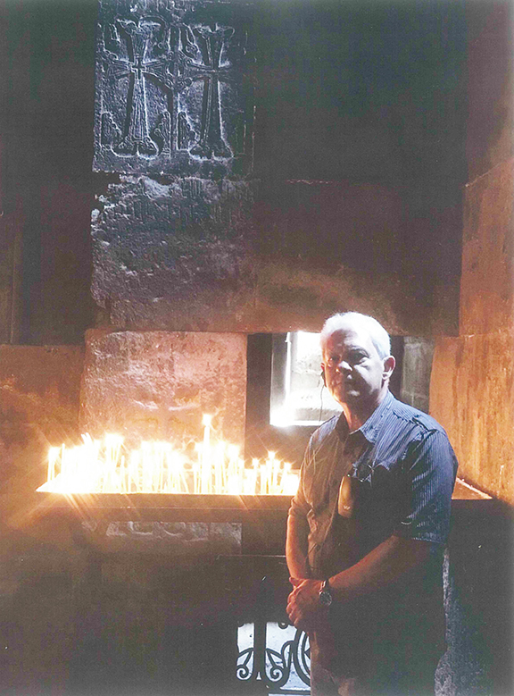 The author lights a candle at a chapel in Armenia