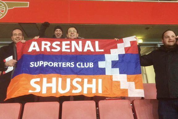 Arsenal fans display the Artsakh flag from bleachers during the match with Azerbaijan