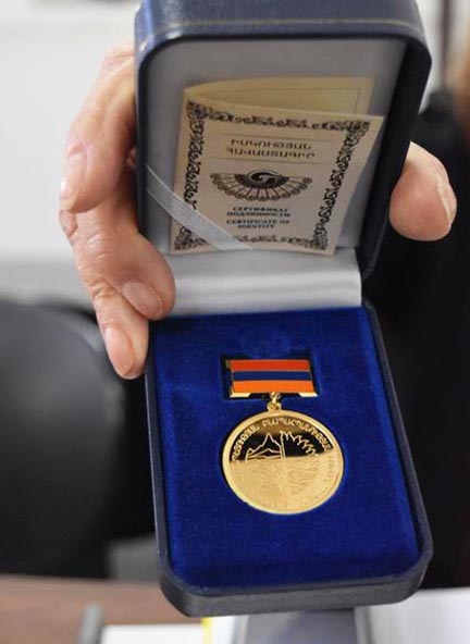 Erik Grigoryan presented this official gold medal of recognition to Carolyn Mugar in the days after the Forest Summit