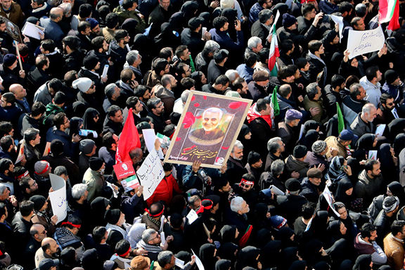  Iranian mourners lift a picture of slain military commander Qasem Soleimani during a funeral procession in the capital Tehran on January 6, 2020, (AFP Photo by ATTA KENARE)