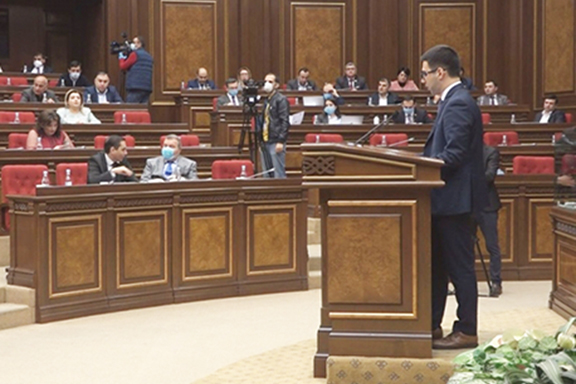 Armenia's Justice Minister Rustam Badassyan addresses lawmakers who are wearing protective masks